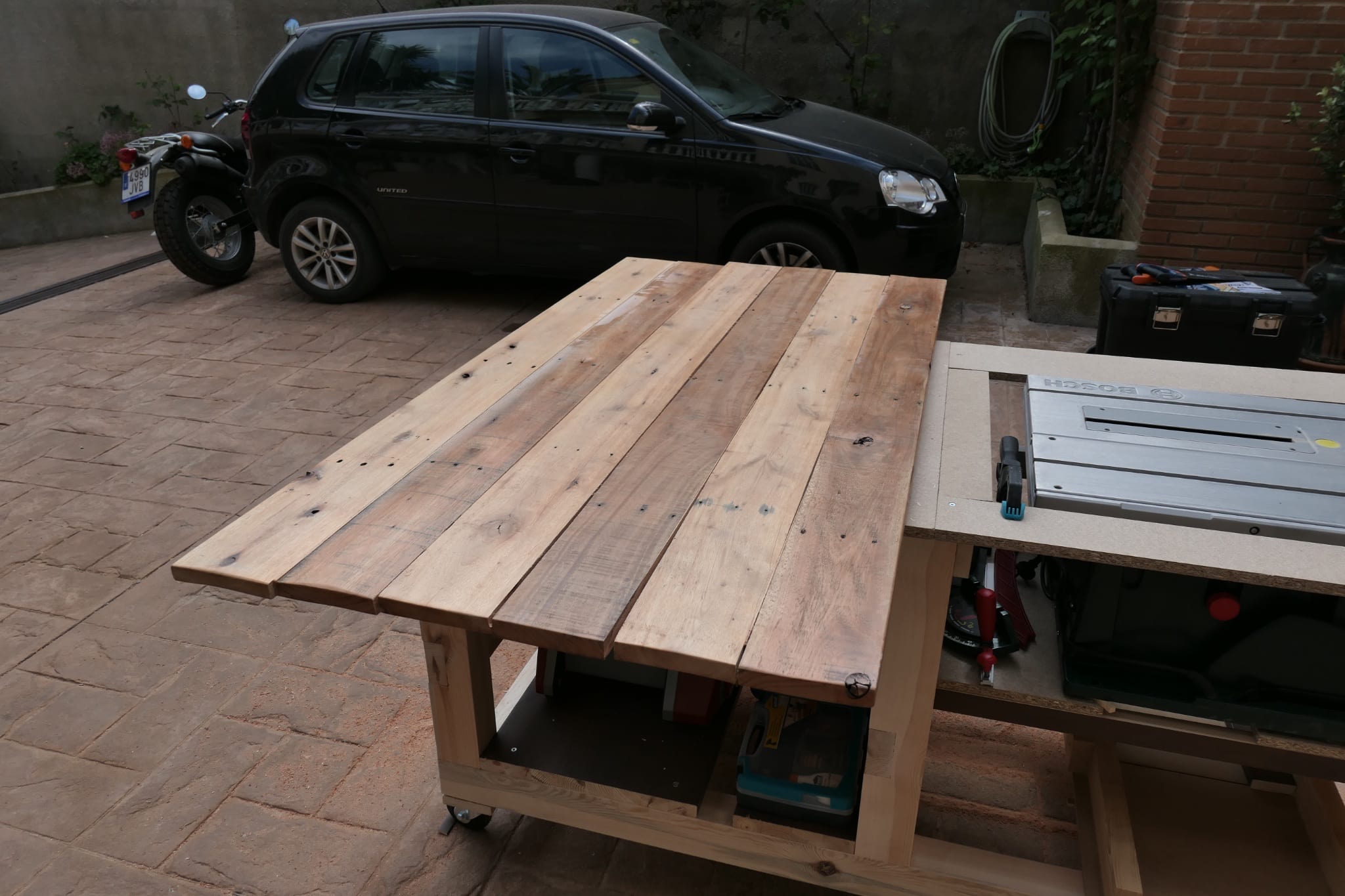Several wooden boards lined up on a workbench ready to be glued together {caption: The original top laid out and ready to be jointed and planed}