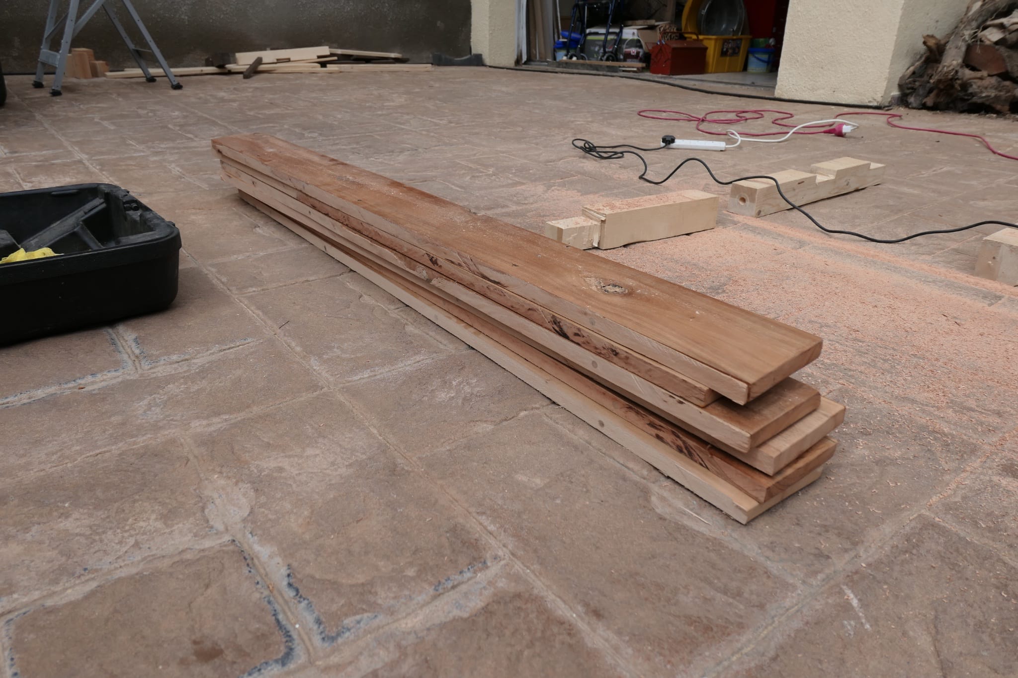 A stack of wooden boards cut from the original desk with a circular saw {caption: The boards stacked after being ripped down with a circular saw}